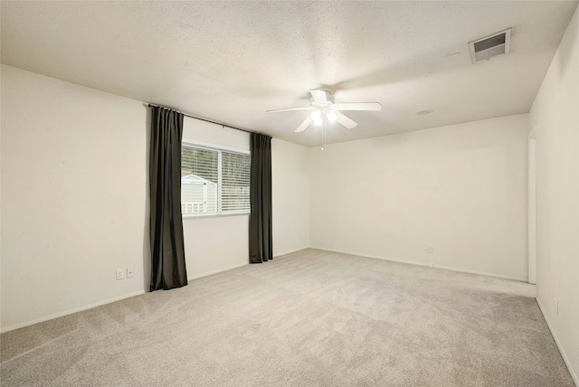 carpeted empty room featuring ceiling fan and a textured ceiling