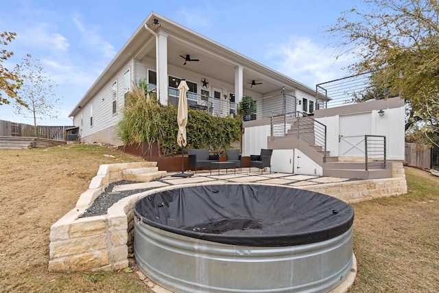 back of house with ceiling fan, a yard, and a balcony