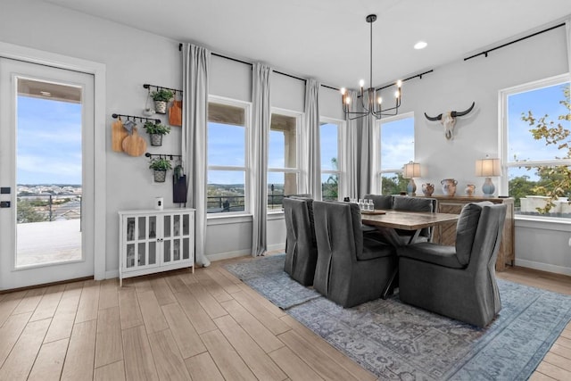 dining area featuring a wealth of natural light, baseboards, an inviting chandelier, and wood finished floors