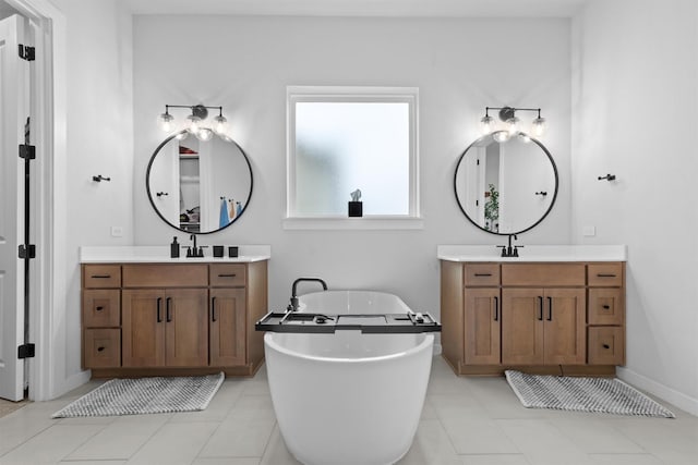 bathroom with tile patterned flooring, a bath, and vanity