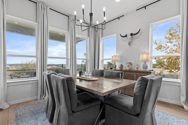 dining area with light hardwood / wood-style flooring and a notable chandelier