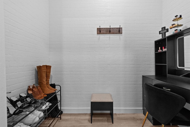 office space featuring light hardwood / wood-style flooring and brick wall