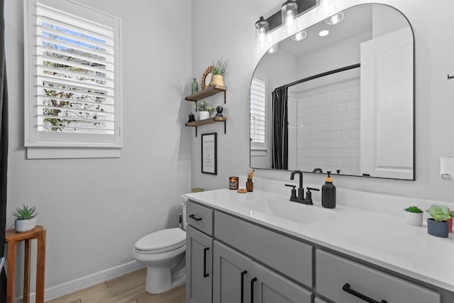 bathroom featuring a shower with curtain, hardwood / wood-style flooring, toilet, and vanity