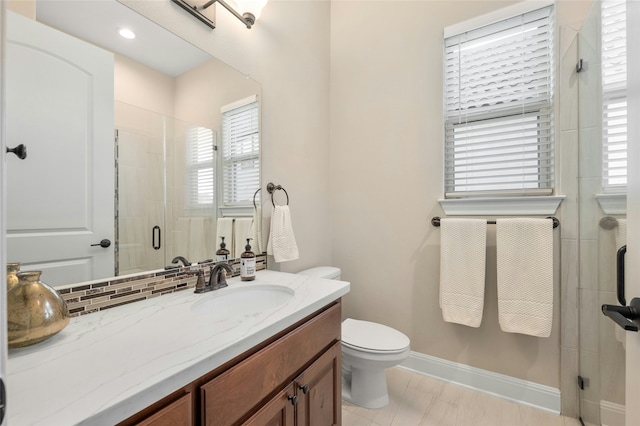 bathroom with backsplash, toilet, walk in shower, and vanity