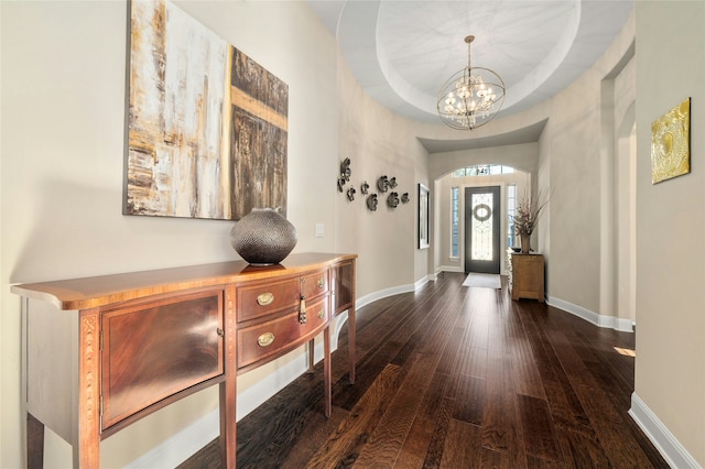 foyer featuring a chandelier, dark hardwood / wood-style floors, and a tray ceiling