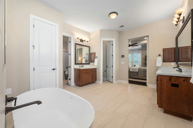 bathroom featuring ceiling fan, a bathtub, vanity, and tile patterned flooring