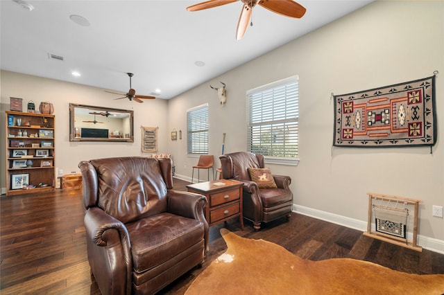 sitting room with ceiling fan and dark wood-type flooring