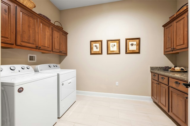 washroom with washing machine and clothes dryer and cabinets