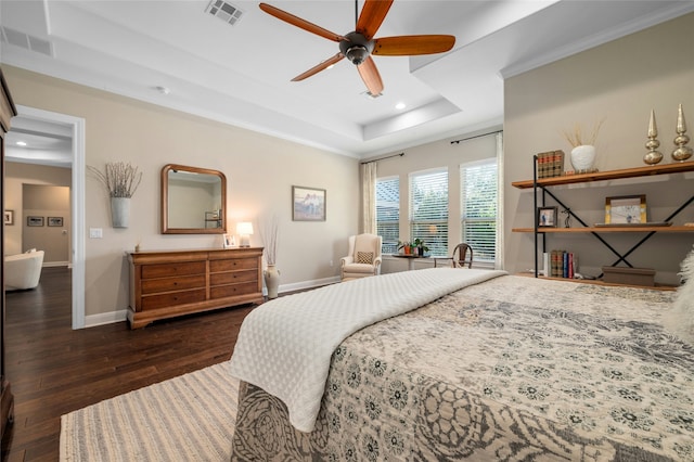 bedroom featuring ceiling fan, ornamental molding, dark hardwood / wood-style floors, and a tray ceiling