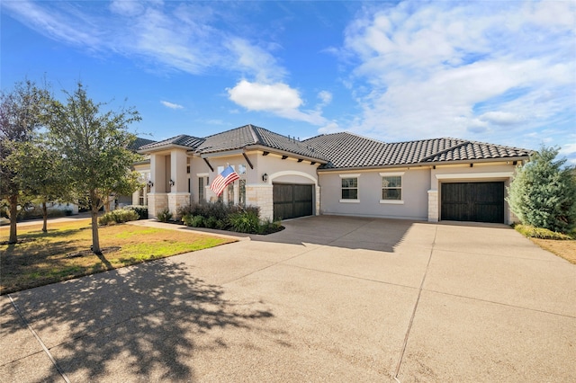 mediterranean / spanish-style home featuring a front yard and a garage