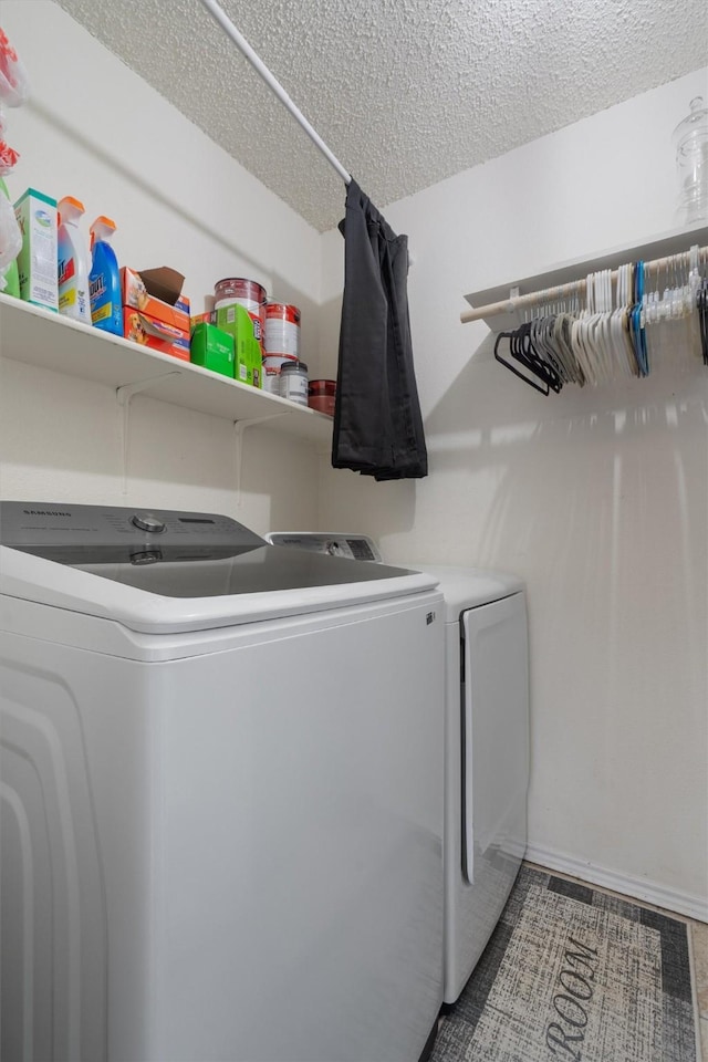 laundry area featuring separate washer and dryer, a textured ceiling, and tile patterned flooring