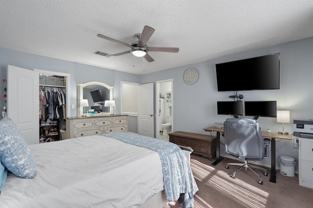 bedroom featuring ceiling fan, carpet, a textured ceiling, a walk in closet, and a closet