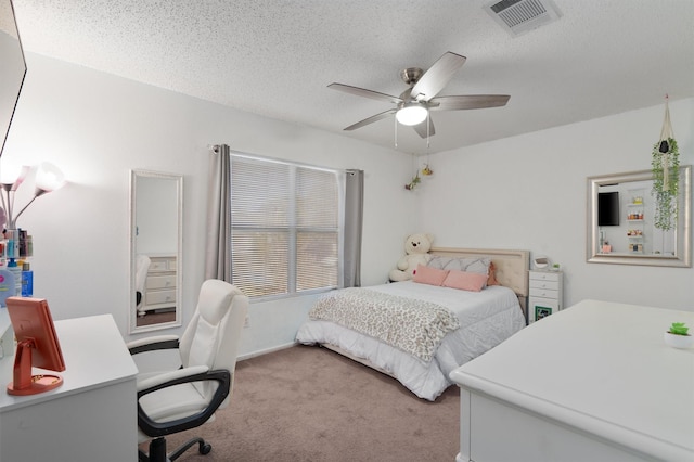 carpeted bedroom with ceiling fan and a textured ceiling