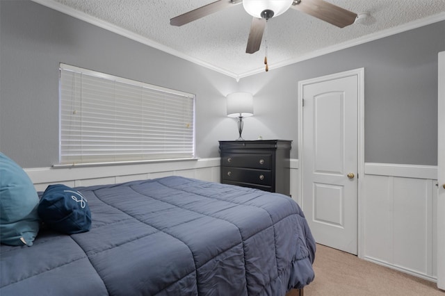 carpeted bedroom with ceiling fan, crown molding, and a textured ceiling