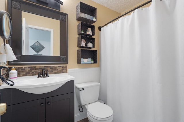 bathroom with toilet, backsplash, a textured ceiling, and vanity