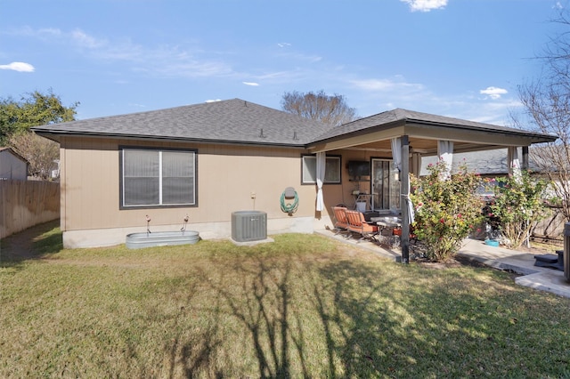 back of property with a lawn and central AC