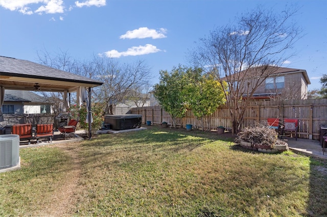 view of yard featuring ceiling fan, a hot tub, a patio, and central AC unit