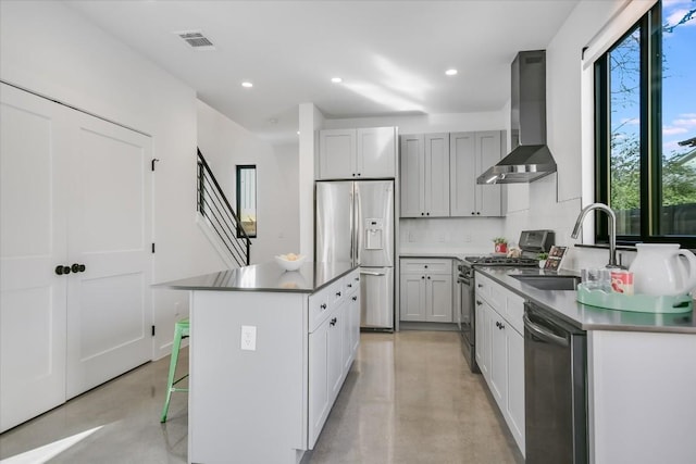 kitchen featuring visible vents, appliances with stainless steel finishes, finished concrete floors, a sink, and wall chimney exhaust hood