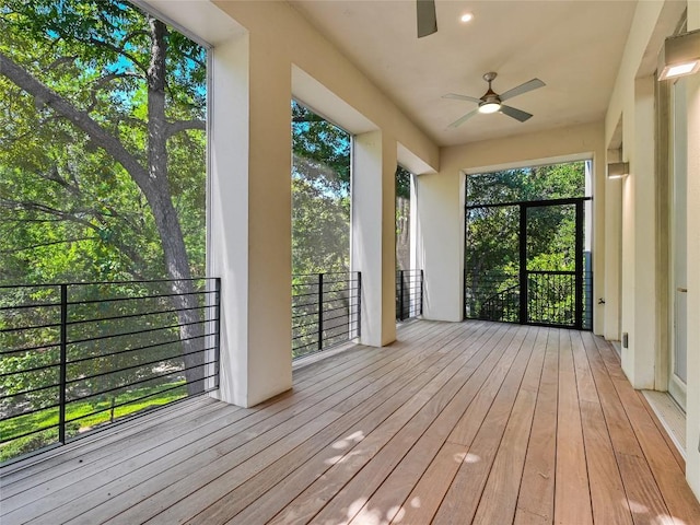 unfurnished sunroom with ceiling fan