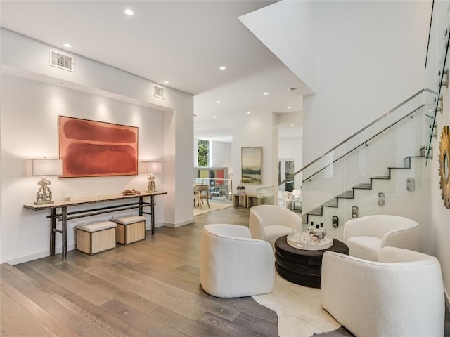 living room with recessed lighting, visible vents, stairway, and wood finished floors