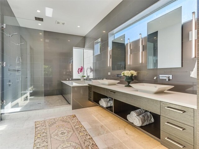 bathroom with vanity, shower with separate bathtub, and tile walls