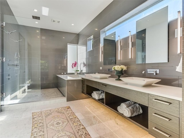 bathroom with visible vents, a sink, a shower stall, and a garden tub