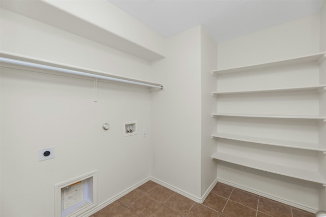 laundry room featuring washer hookup, hookup for a gas dryer, hookup for an electric dryer, and dark tile patterned flooring