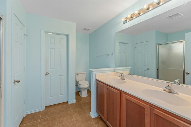 12206 Athens St, Manor, TX 78653 - bathroom featuring double vanity, tile patterned floors, a shower with door, and toilet