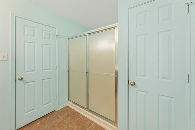 12206 Athens St, Manor, TX 78653 - bathroom featuring tile patterned flooring and a shower with door