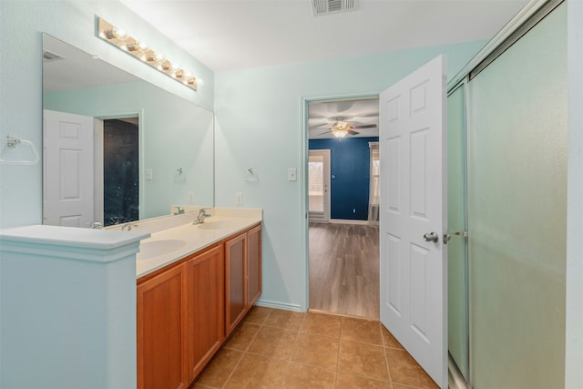 bathroom with tile patterned flooring, walk in shower, ceiling fan, and vanity