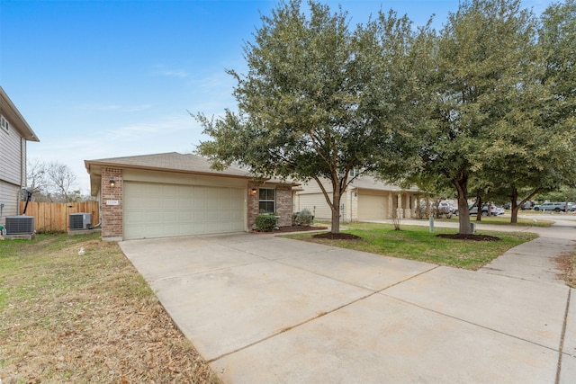 view of front of home with cooling unit, a garage, and a front lawn