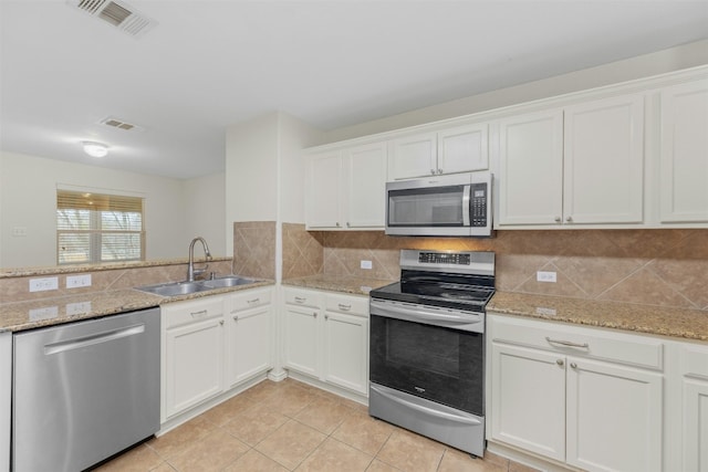 12206 Athens St, Manor, TX 78653 - kitchen featuring appliances with stainless steel finishes, a sink, white cabinetry, and light tile patterned floors