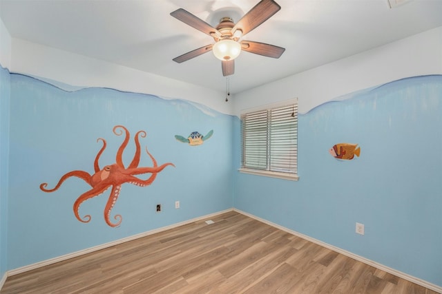 12206 Athens St, Manor, TX 78653 - empty room featuring wood finished floors, a ceiling fan, and baseboards
