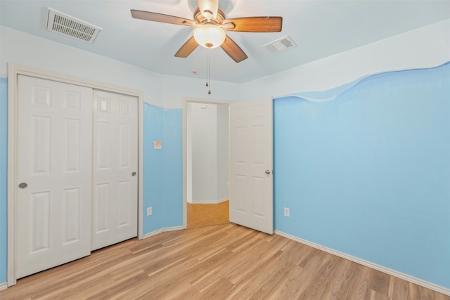 unfurnished bedroom featuring ceiling fan, a closet, and light wood-type flooring