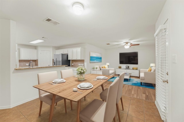 dining area with ceiling fan, sink, and light tile patterned floors