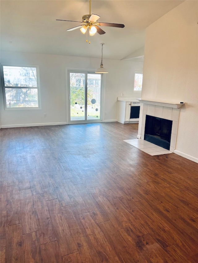 unfurnished living room featuring ceiling fan, a fireplace, dark hardwood / wood-style flooring, and lofted ceiling