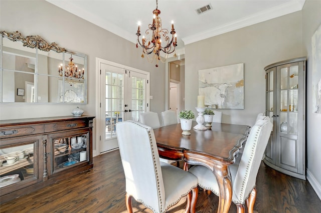 dining space featuring a chandelier, dark hardwood / wood-style flooring, crown molding, and french doors