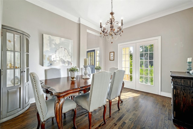 dining space featuring crown molding, dark wood-type flooring, a notable chandelier, and french doors