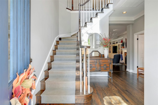 staircase with hardwood / wood-style flooring and crown molding