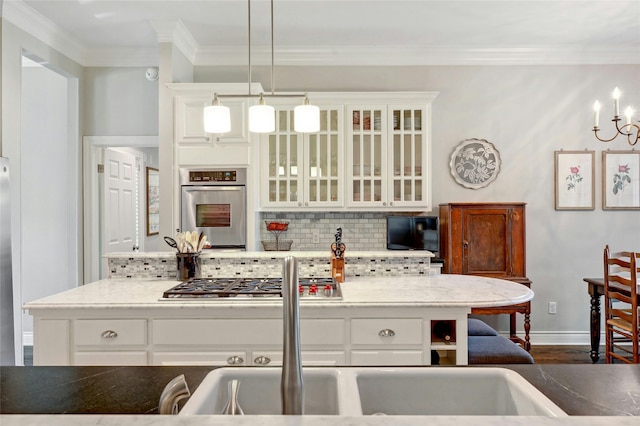 kitchen with light stone countertops, stainless steel appliances, white cabinetry, and pendant lighting