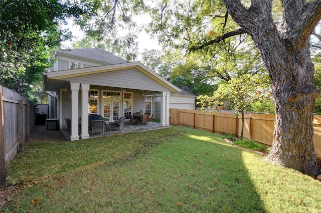 back of property featuring a patio area, a lawn, and french doors