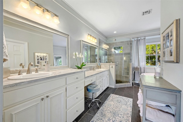 bathroom featuring vanity, tile patterned floors, and a shower with door