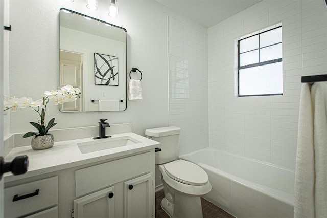 full bathroom featuring hardwood / wood-style flooring, toilet, tiled shower / bath, and vanity