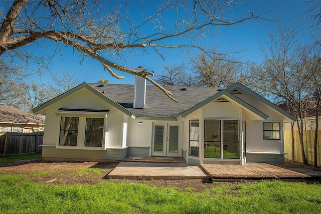 back of property featuring a wooden deck, a patio area, a yard, and french doors