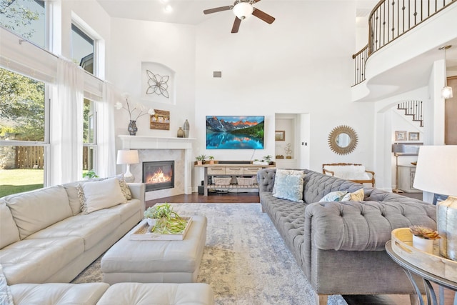 living room featuring ceiling fan, a high ceiling, and hardwood / wood-style floors