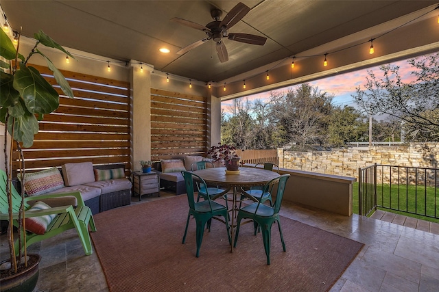 patio terrace at dusk with an outdoor living space and ceiling fan