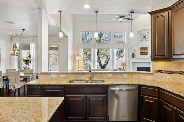 kitchen featuring dark brown cabinets, sink, backsplash, and stainless steel dishwasher