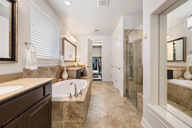 bathroom featuring vanity and independent shower and bath