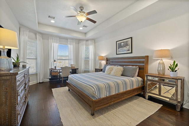 bedroom featuring ceiling fan, a raised ceiling, and dark hardwood / wood-style floors