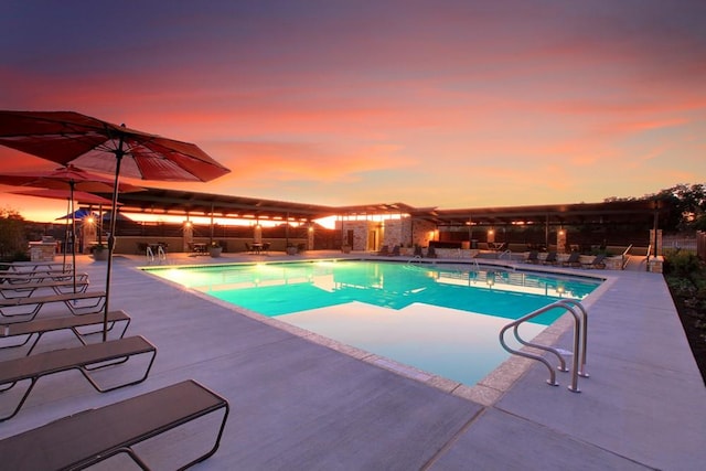 pool at dusk with a patio